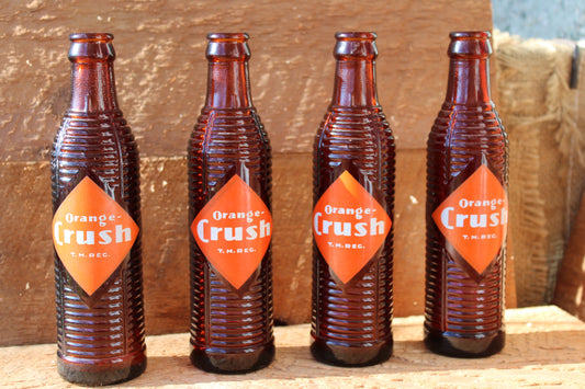 Circa 1940s Orange Crush ~ Crushy mascot ~ Lot of four ~ Brown Soda bottles